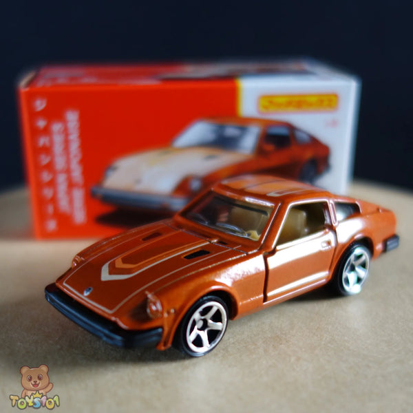 Orange 1:64 scale diecast Nissan 280ZX in front of its retro style Matchbox packaging.